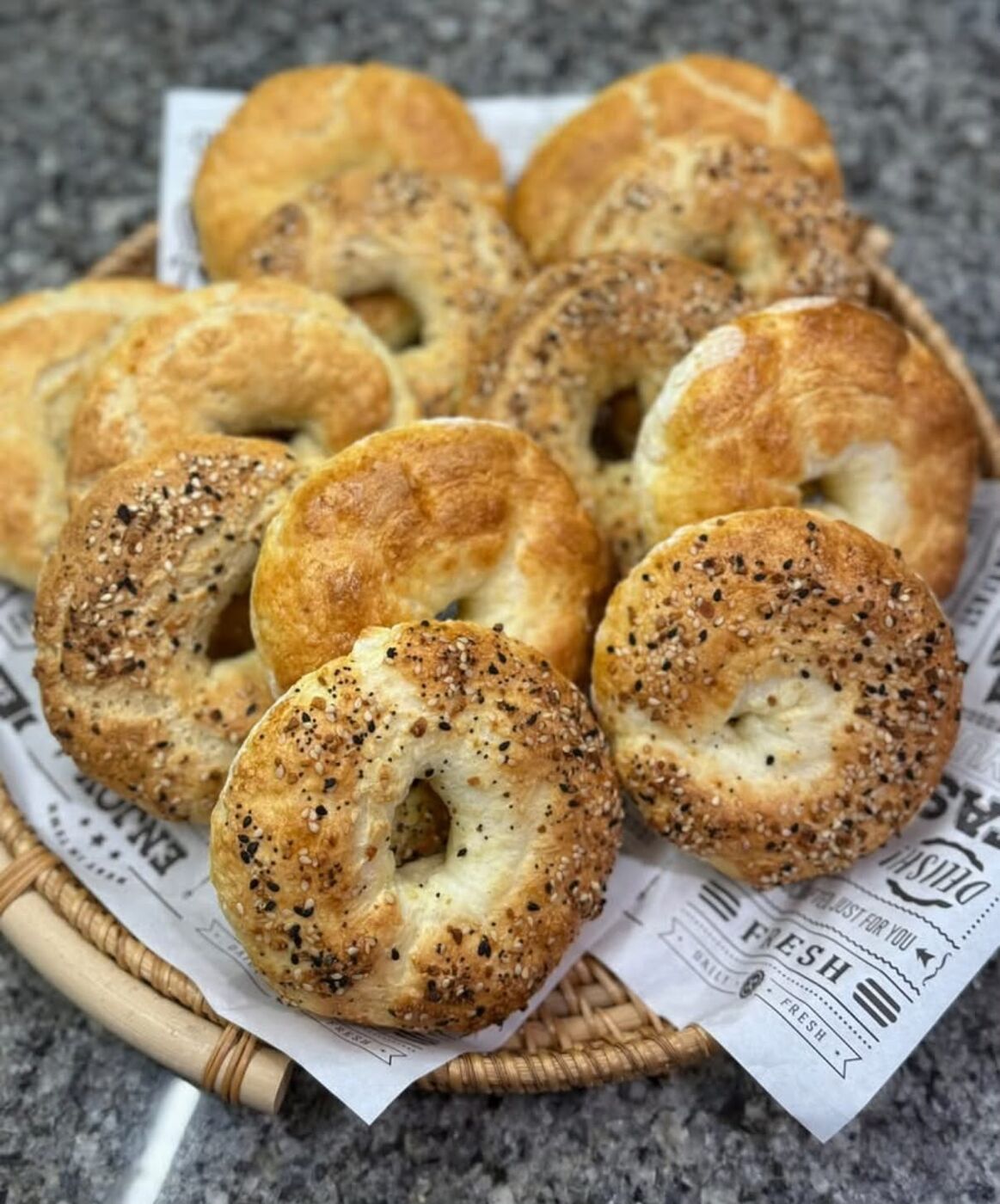 A dozen mixed gluten-free bagels in a basket
