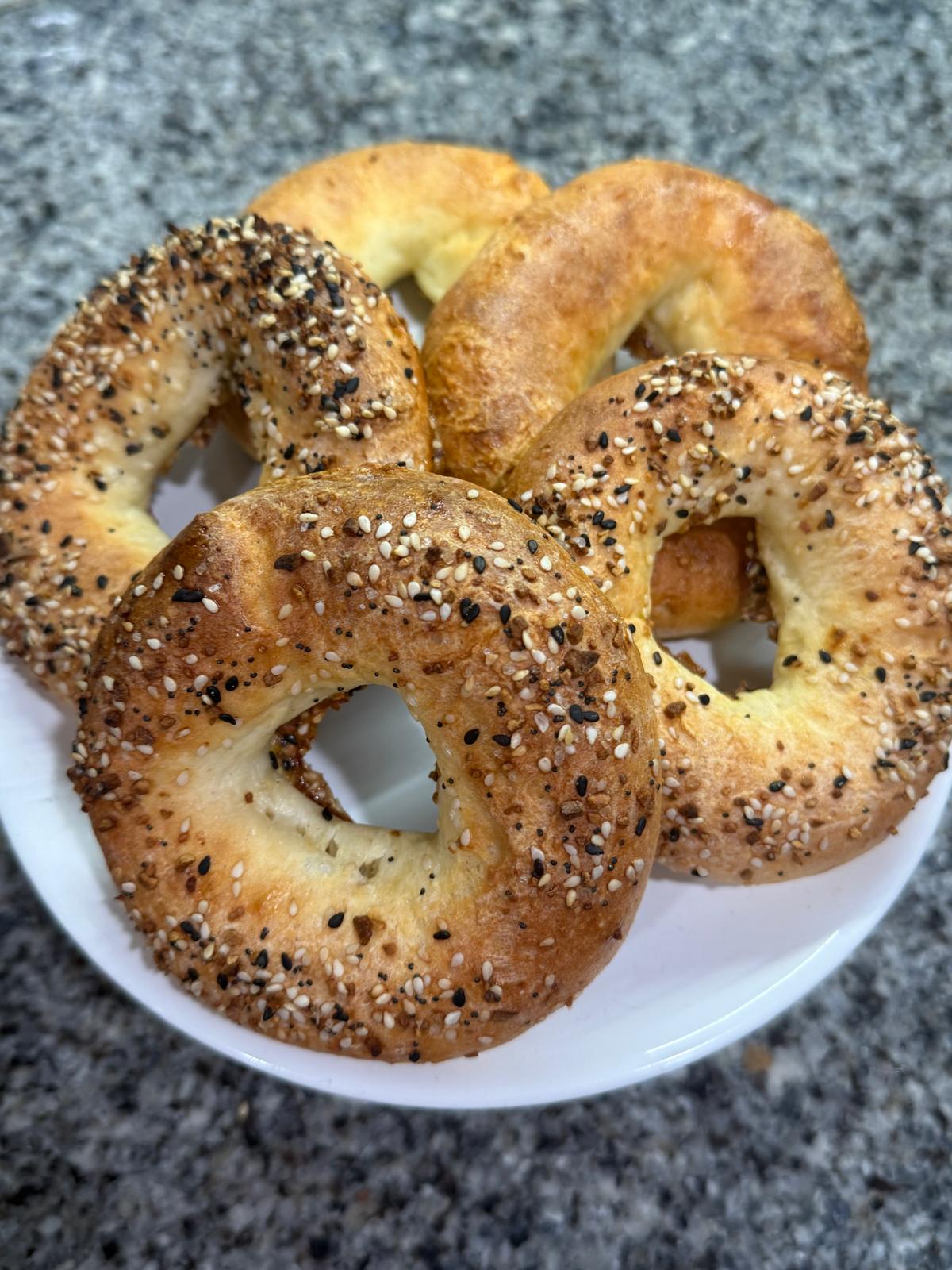 Plain and everything gluten-free bagels on a plate